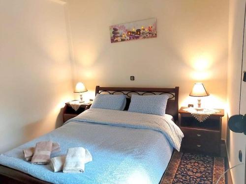 a bedroom with a large bed with towels on it at Helen's House in Tríkala