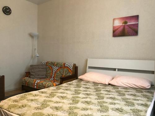 a bedroom with a bed with two pillows and a chair at Apartment Maria in Zelenograd