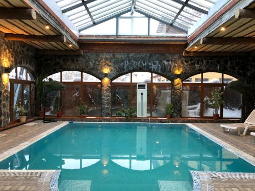 a swimming pool in a building with a glass ceiling at Guest House Valeria in Velikiy Novgorod