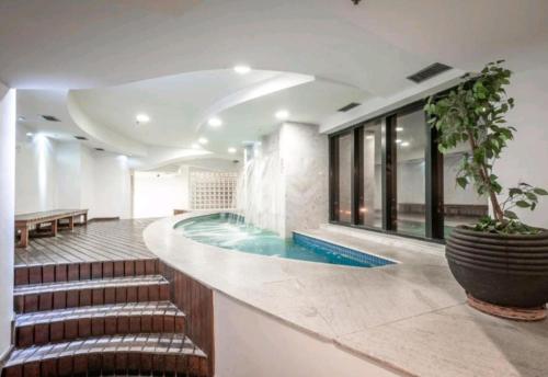 a swimming pool in a building with a stairway leading to a swimming pool at Guarulhos flat services, aeroporto in Guarulhos