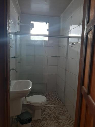 a bathroom with a toilet and a sink at Casa hibiscus in Itacaré