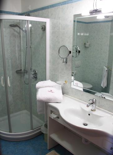 a bathroom with a shower and a sink and a showerspective at Sartori's Hotel in Trento