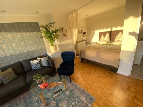 a living room with a couch and a bed at Apartment mit Sonnenbalkon und NETFLIX im Zentrum in Sankt Augustin