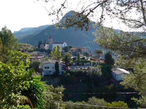 una pequeña ciudad en una colina con una iglesia en Mountain Finca with Pool, en Puigpunyent