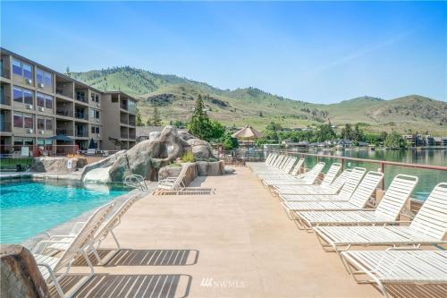 a row of lounge chairs next to a swimming pool at Grandview Lake Chelan- Waterfront View, Pool, Hot tub, Golf, 1 Min To Downtown in Chelan
