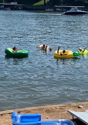 a group of people floating on tubes in the water at Sunset Beach Resort in Osage Beach