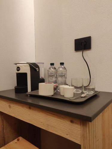a tray with glasses and bottles of water on a table at BAITA LARIX BORMIO in Bormio