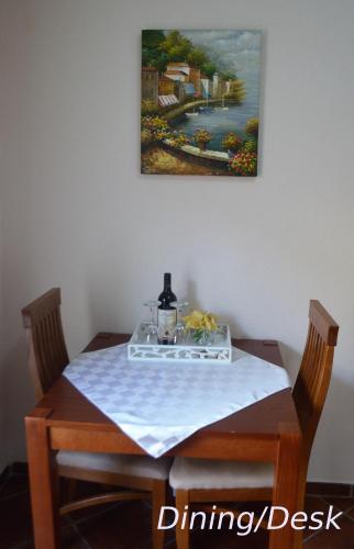 a dining room table with a painting on the wall at Fortezza Apartment in Herceg-Novi