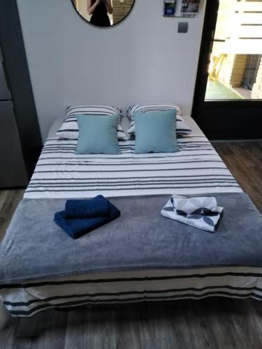 a large bed with blue and white sheets and blue pillows at L'Oustal in Montech