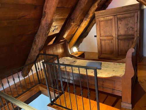 an attic room with a bed and a wooden cabinet at Casa indipendente con camino e mansarda. in Re