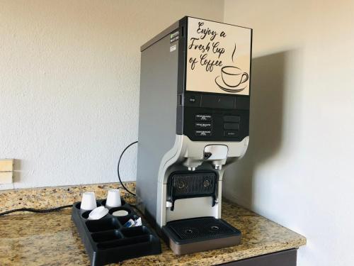 a coffee machine sitting on top of a counter at Motel 6 Tulsa, OK Airport in Tulsa