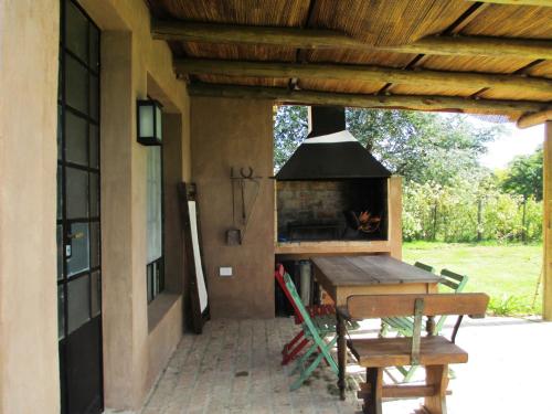 an outdoor kitchen with a fireplace on a patio at La Pausa Lodge de Campo in Duggan