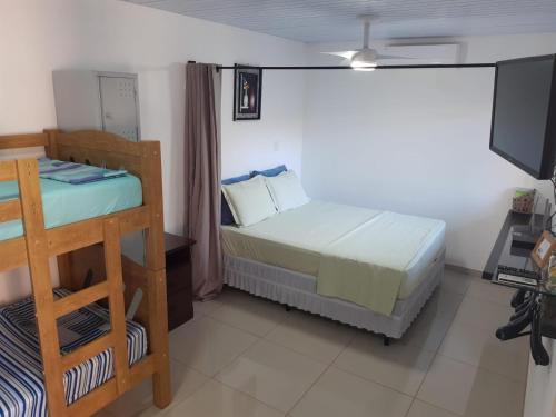 a bedroom with a bed and a bunk bed at Suíte Santin: o seu conforto está aqui! in Foz do Iguaçu