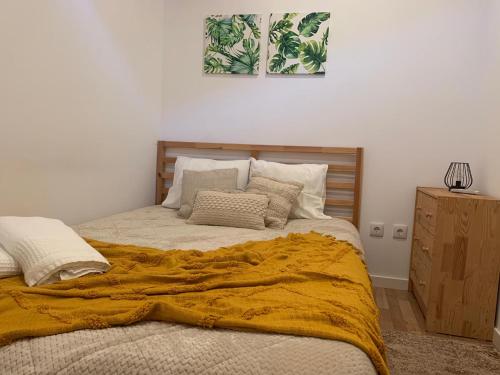 a bedroom with a bed with a yellow blanket on it at CASA DO PENEDO - Um Segredo na Serra da Estrela in Quintãs de Baixo