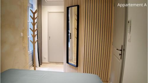 a mirror on a wall next to a bedroom at Holiday in Arles: Appartement de l'Amphithéâtre in Arles