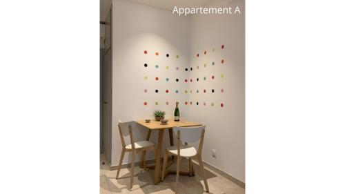 una mesa y sillas en una habitación con una pared en Holiday in Arles: Appartement de l'Amphithéâtre en Arlés
