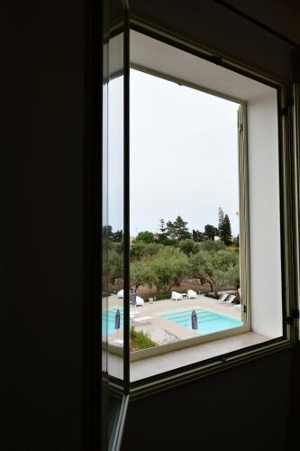 a window with a view of a swimming pool at Inkantu B&B in Terrasini