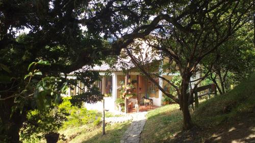 a house in the middle of a yard with trees at Granja Los Conejos in Ramiriquí