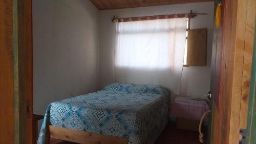 ein kleines Schlafzimmer mit einem Bett und einem Fenster in der Unterkunft Granja Los Conejos in Ramiriquí