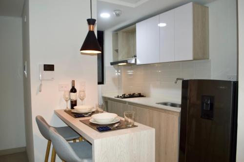 a kitchen with a table and a refrigerator at Apartamento con vista y ubicación privilegiada in Armenia