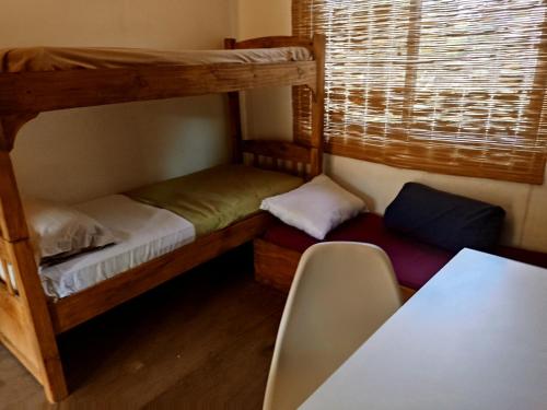 Una pequeña habitación con dos literas y una mesa. en El Barco, en Punta del Este