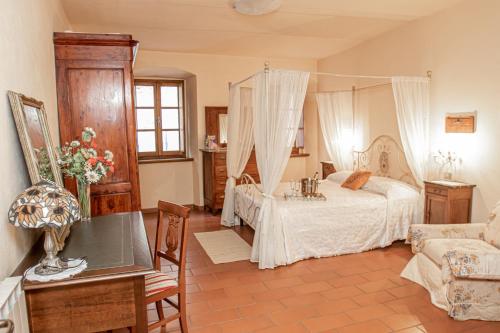Palazzo del Duca في Tavernelle: غرفة نوم بسرير وطاولة واريكة