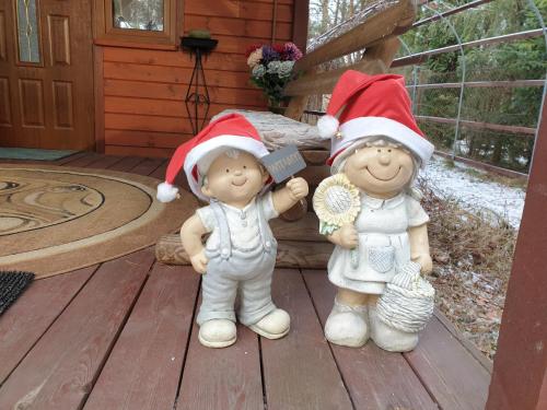 a group of three christmas statues sitting on a porch at Brązowy Domek - Tleń, Bory Tucholskie in Tleń
