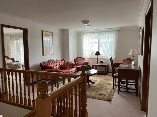 a living room with a couch and chairs and a table at Luxury 4 bedroom house in Deewhy