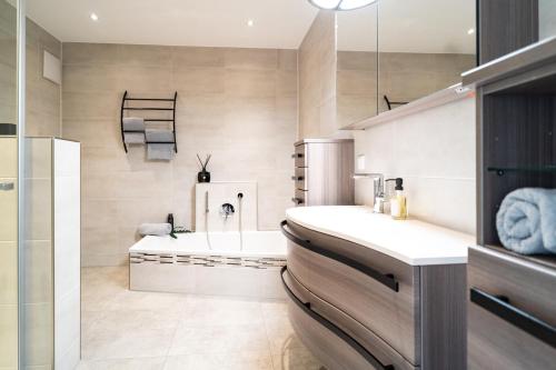 a bathroom with a bath tub and a sink at Ferienwohnung Oba‘doba Falke in Pfronten