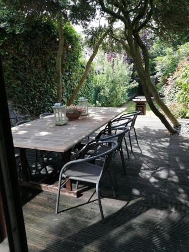 a wooden table and chairs sitting on a patio at Huize La Passion vacationhouse 10 min walk from the sea in Middelkerke