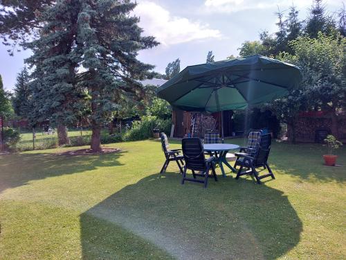 a table and chairs under an umbrella in a yard at Ferienzimmer Lichtlein in Rostock