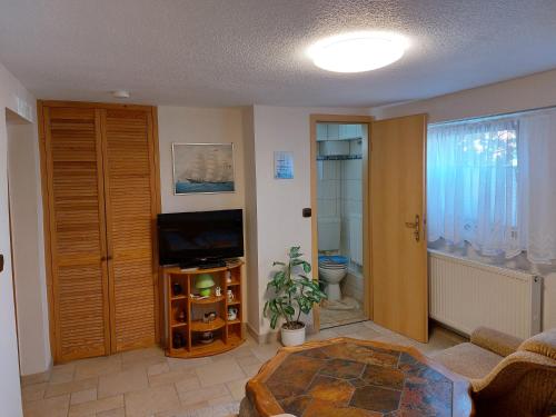 a living room with a television and a bathroom at Ferienzimmer Lichtlein in Rostock