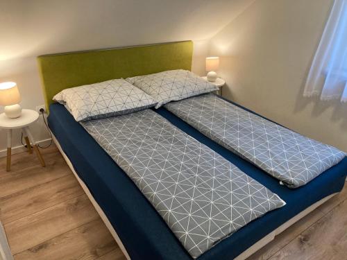 Bett in einem Zimmer mit zwei Kissen darauf in der Unterkunft Domek pod lasem in Pogorzelica