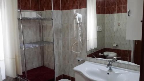 a bathroom with a shower with a sink and a toilet at B&B il Tulipano in Rogliano