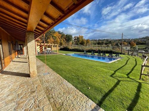 a yard with a swimming pool and a house at Casa de Pelicas - Celorico de Basto in Celorico de Basto