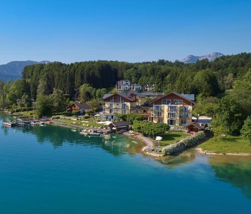 a group of houses on the shore of a lake at Hotel Stadler am Attersee in Unterach am Attersee