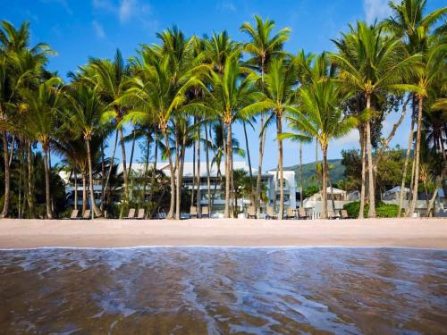 a group of palm trees on the beach at Palm Cove Beachside Apartments - Sea and Mountain Views in Palm Cove