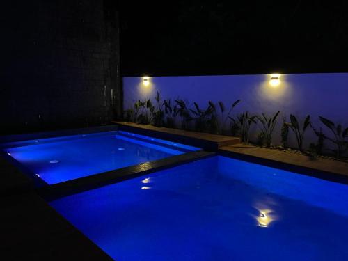 a blue swimming pool in a dark room with lights at Hotel Boutique Madre Tierra in Mazunte