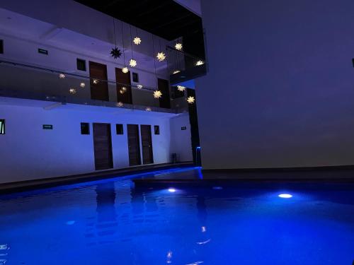 a swimming pool with blue lights in a building at Hotel Boutique Madre Tierra in Mazunte