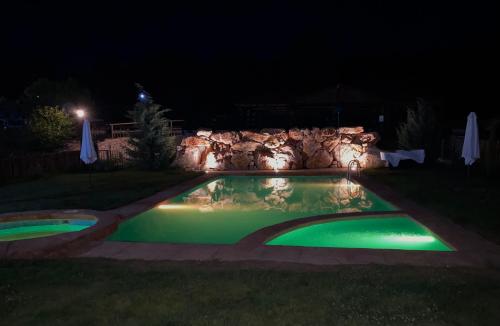 a swimming pool lit up at night at El BURGO DE OSMA ALOJAMIENTO RURAL VILLA BAGH in El Burgo de Osma
