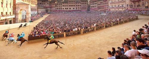 a crowd of people watching people riding horses in an arena at Laura Chianti Vacanze in Poggibonsi