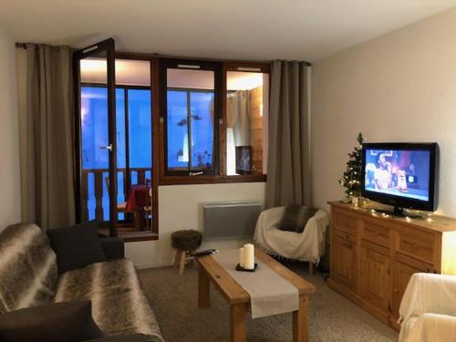 a living room with a couch and a tv at Vue panoramique - 4pers - parking in La Mongie