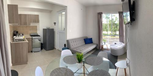 a kitchen and living room with a table and a couch at Departamento Vacacional 2 habitaciones vista a la alberca by EITA in Cancún