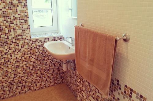 a bathroom with a sink and a window and a towel at Viesu māja Sprīdīši in Tērvete