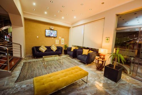 a large living room with a yellow couch and chairs at Grima Hotel in Huánuco