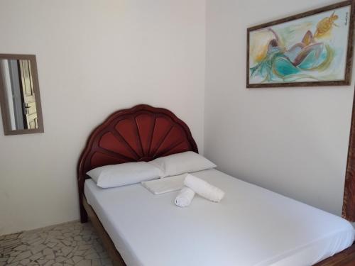 a bedroom with a bed with a wooden headboard at Vi&Li Suites in Aracaju