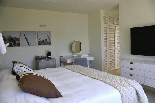 a bedroom with a bed and a flat screen tv at Posada Tamarindo in José Ignacio