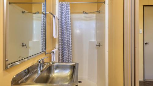 uma casa de banho com um lavatório de aço inoxidável e um chuveiro em Emerald Tourist Park em Emerald