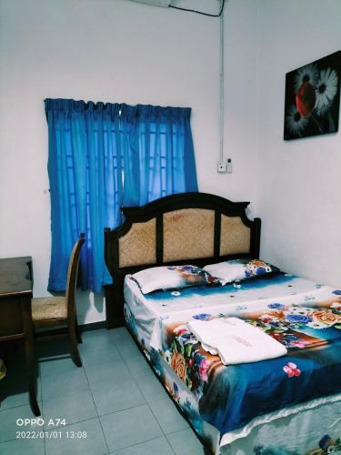 a bedroom with a bed with a blue curtain at Hotel Murah Pasir Puteh in Pasir Puteh