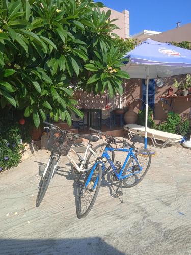 a blue bike parked next to an umbrella at Modern 1-bedroom with BBQ & Roof Garden near Beach in Stalos